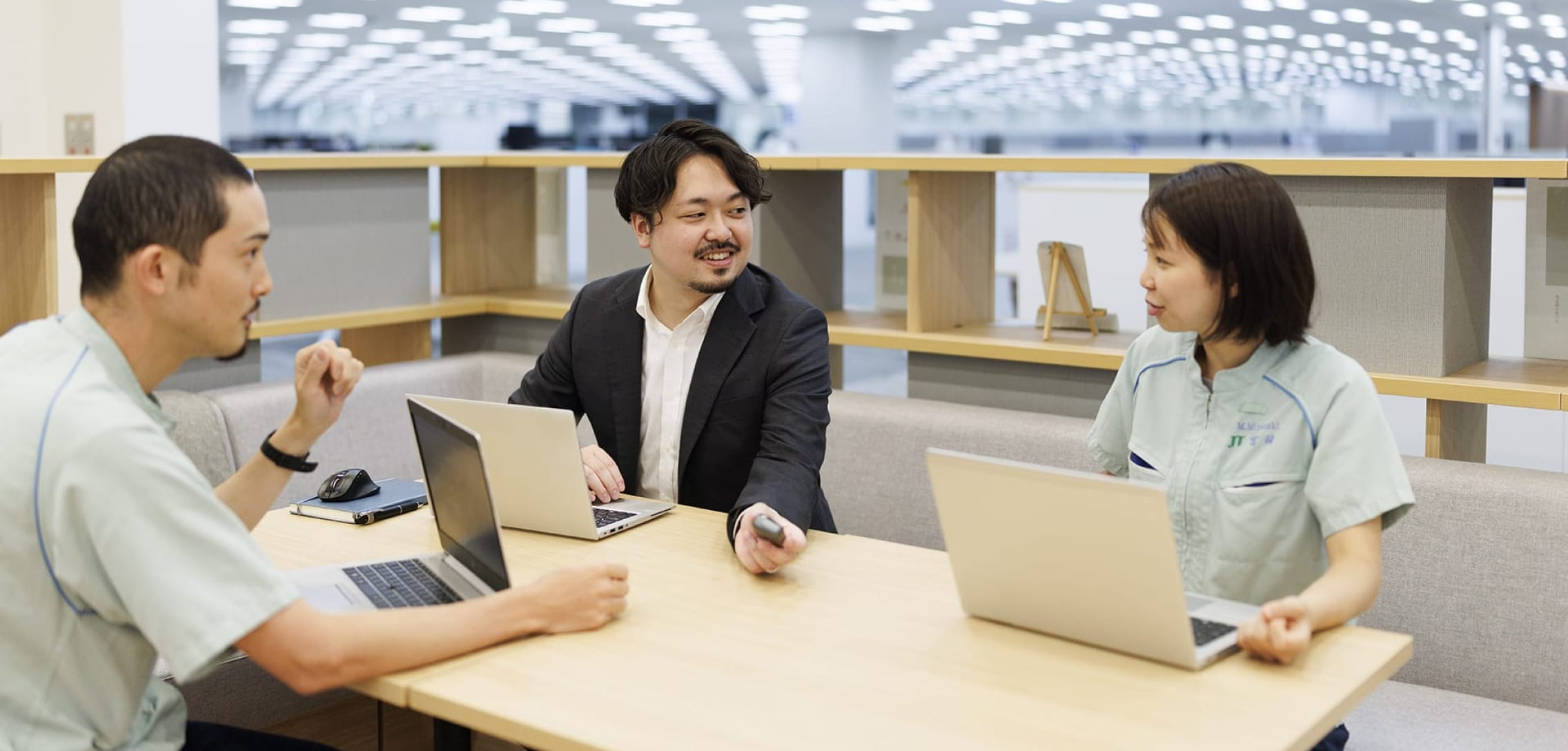 同僚2人と会話をする藤倉さんの写真